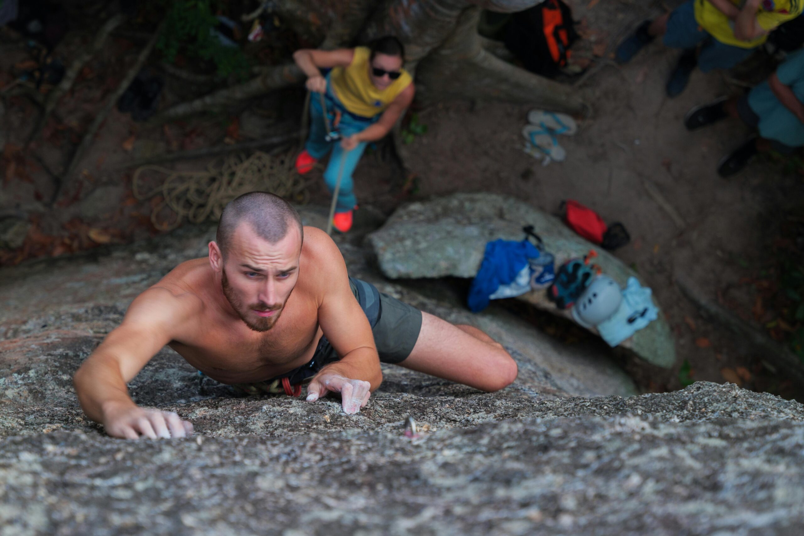 A determined man rock climbs a steep wall in Ko Tao, Thailand, showcasing strength and effort.